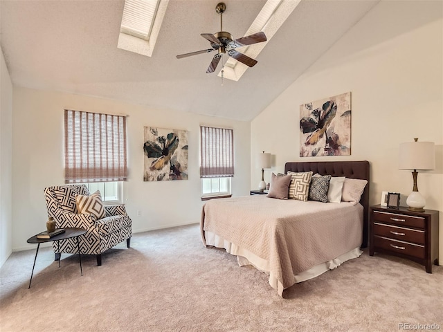 bedroom featuring multiple windows, a skylight, light colored carpet, and ceiling fan