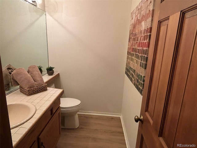 bathroom with wood-type flooring, vanity, and toilet