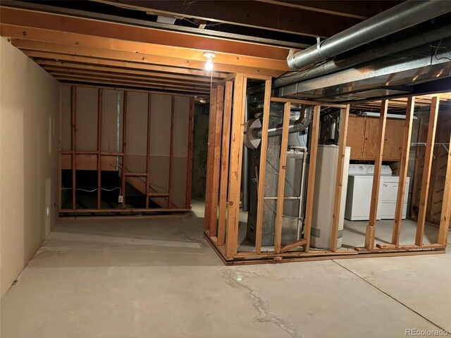 basement featuring water heater and independent washer and dryer