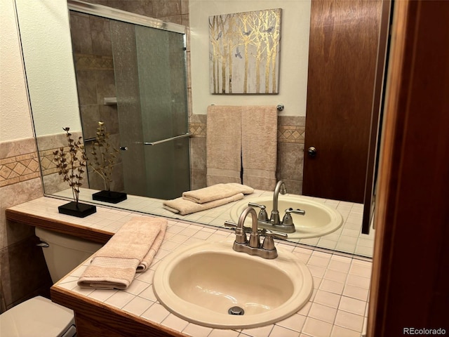 bathroom featuring sink, a shower with shower door, and toilet