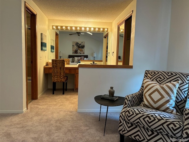 hall featuring light carpet and a textured ceiling