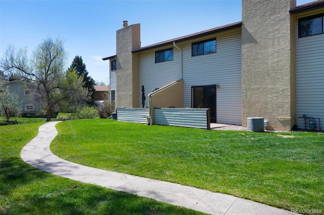 5082 Masheena Ln Unit 4, Colorado Springs, CO 80917 - back of house featuring a chimney, a lawn, and central AC unit