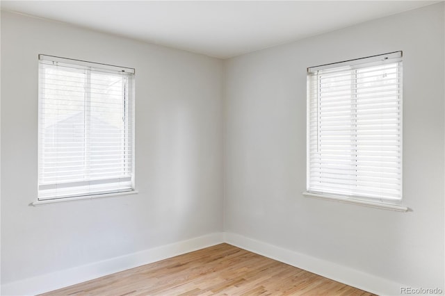 empty room with hardwood / wood-style flooring and plenty of natural light