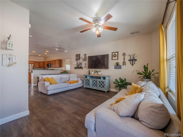 living room featuring plenty of natural light, ceiling fan, and dark hardwood / wood-style flooring