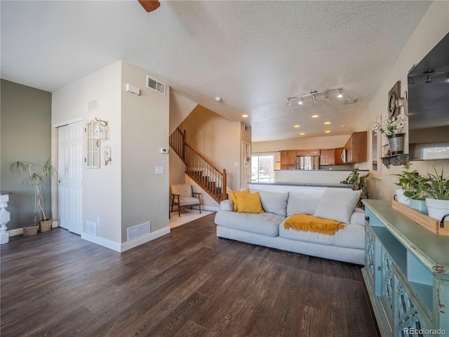 living room with a textured ceiling and dark hardwood / wood-style flooring