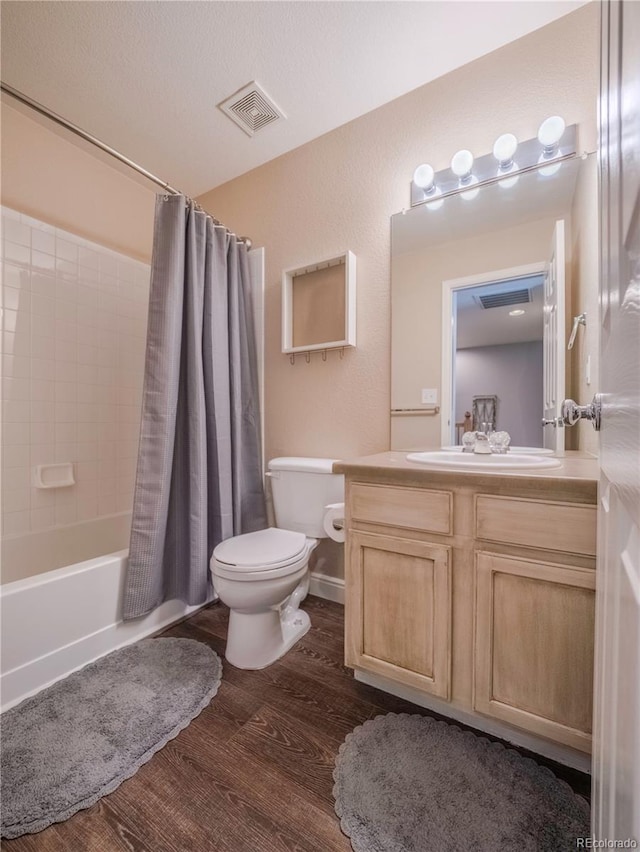 full bathroom with hardwood / wood-style flooring, toilet, shower / bath combination with curtain, and vanity