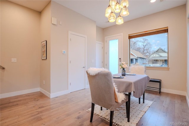 dining area featuring light wood-type flooring and a chandelier