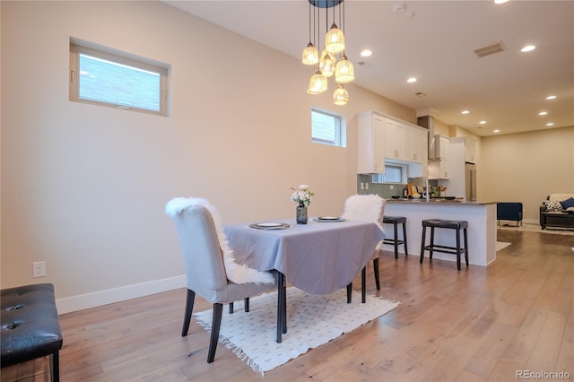 dining area with a wealth of natural light and light hardwood / wood-style floors