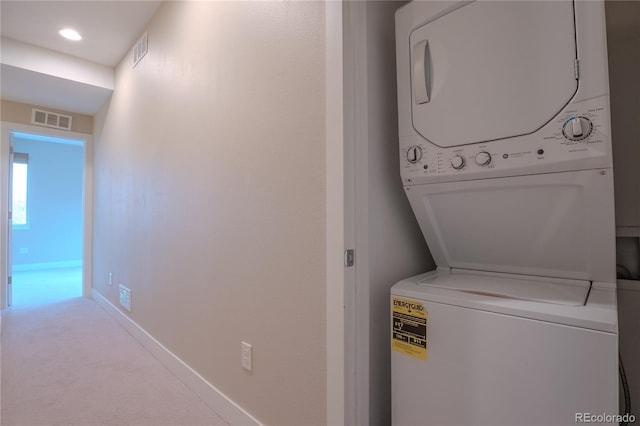 laundry area with light carpet and stacked washing maching and dryer