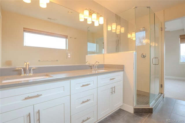 bathroom featuring a shower with shower door, vanity, and tile patterned flooring