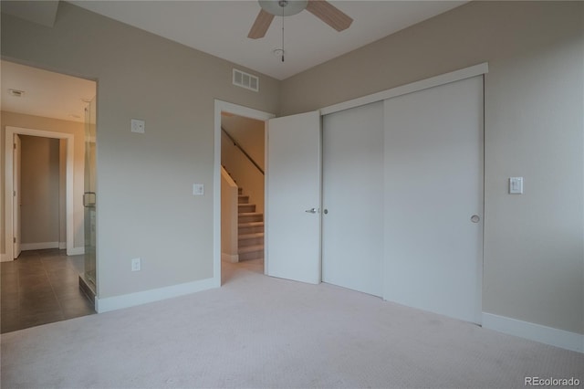 unfurnished bedroom featuring ceiling fan, a closet, and carpet floors