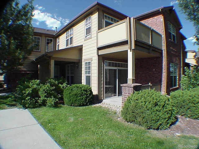 8915 Federal Blvd Unit 104, Westminster, CO 80260 - back of house with a balcony, brick siding, and a yard