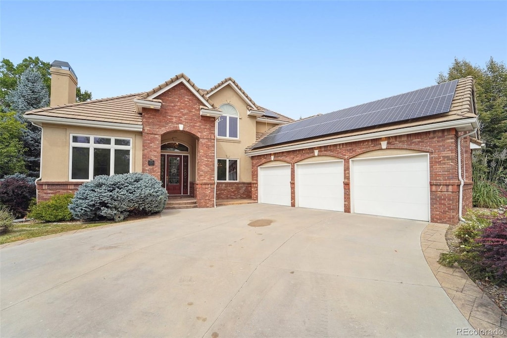 view of front of home featuring a garage and solar panels