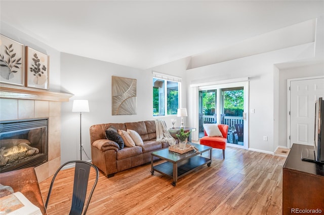 135 Carina Cir Unit 104, Loveland, CO 80537 - living area with light wood-style floors, a tile fireplace, and vaulted ceiling