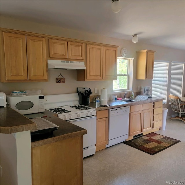 kitchen featuring light tile patterned flooring, light brown cabinetry, white appliances, and sink