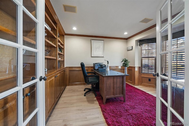 office area with french doors, crown molding, visible vents, light wood-style flooring, and wainscoting