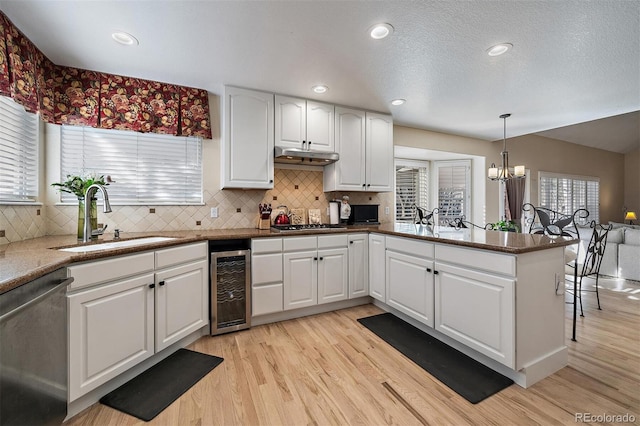 kitchen featuring appliances with stainless steel finishes, wine cooler, light wood-type flooring, and a sink