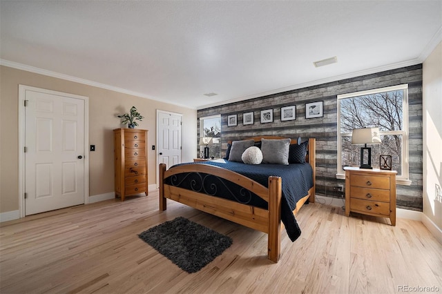 bedroom featuring ornamental molding, light wood-style floors, and baseboards