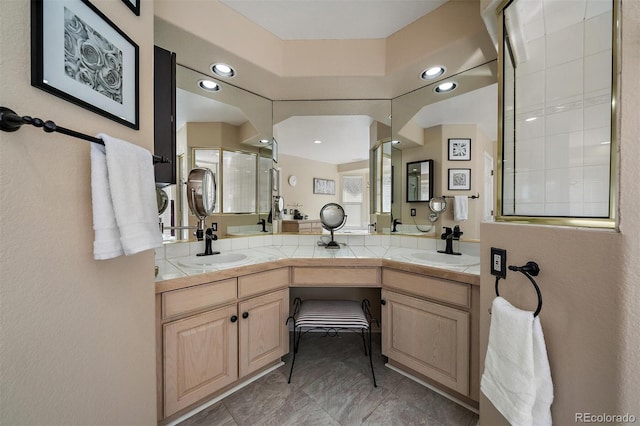 bathroom with double vanity, a shower stall, a sink, and recessed lighting