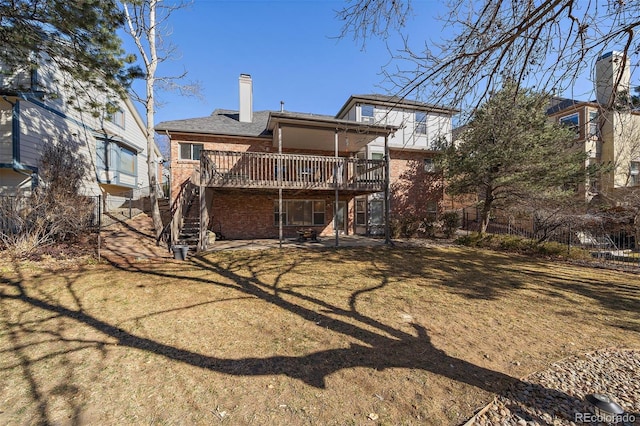 back of house with a deck, a patio, brick siding, stairs, and a chimney