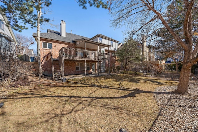 back of property featuring a chimney, stairs, a deck, a yard, and brick siding