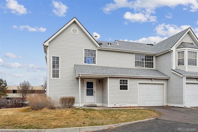 view of front of property featuring a garage, aphalt driveway, a front yard, and a shingled roof