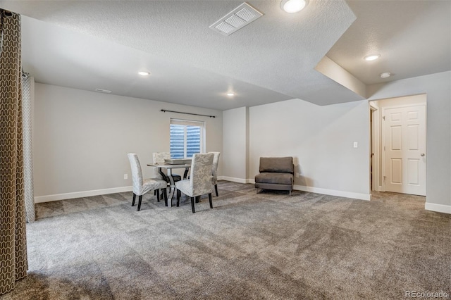 unfurnished dining area with carpet and a textured ceiling