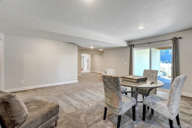 carpeted dining area featuring a textured ceiling