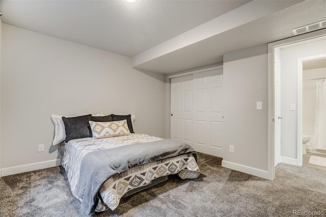 carpeted bedroom featuring ensuite bath