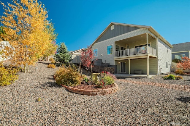 rear view of property featuring a patio area and a balcony