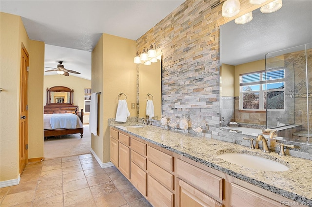 bathroom with a sink, connected bathroom, double vanity, and a ceiling fan