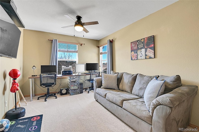 carpeted office space with a textured ceiling and a ceiling fan