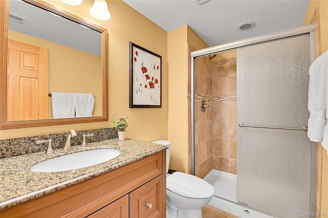 full bathroom featuring visible vents, toilet, a stall shower, and vanity