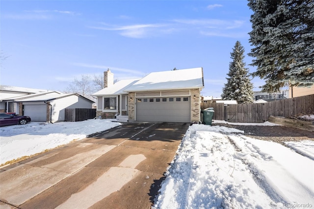 view of front of property featuring a garage, driveway, a chimney, and fence