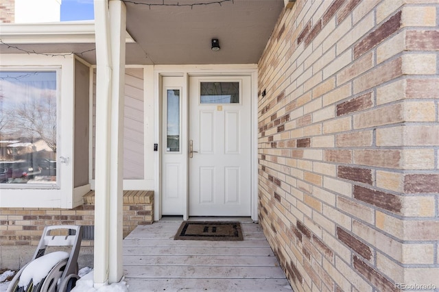 entrance to property featuring brick siding