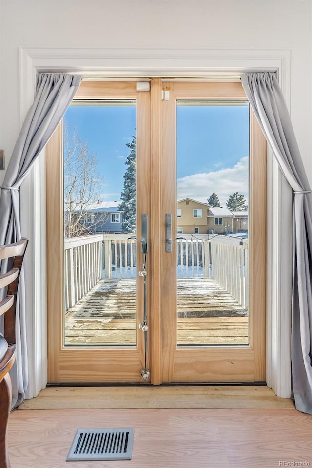 doorway to outside with visible vents and light wood-style floors