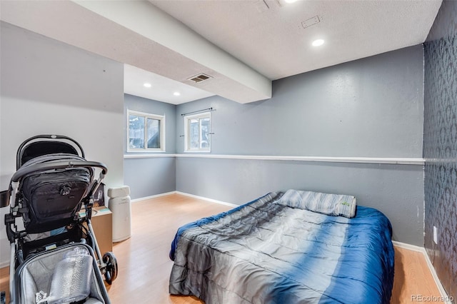 bedroom with visible vents, baseboards, light wood-style flooring, a textured ceiling, and recessed lighting