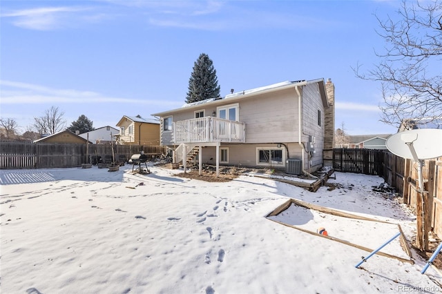 snow covered rear of property featuring stairs, central AC unit, a fenced backyard, and a wooden deck