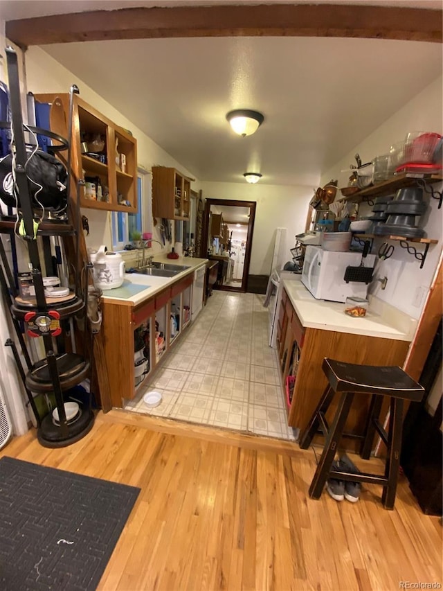 8741 Faraday St, Denver, CO 80229 - kitchen featuring open shelves, white appliances, light wood-style floors, and brown cabinetry