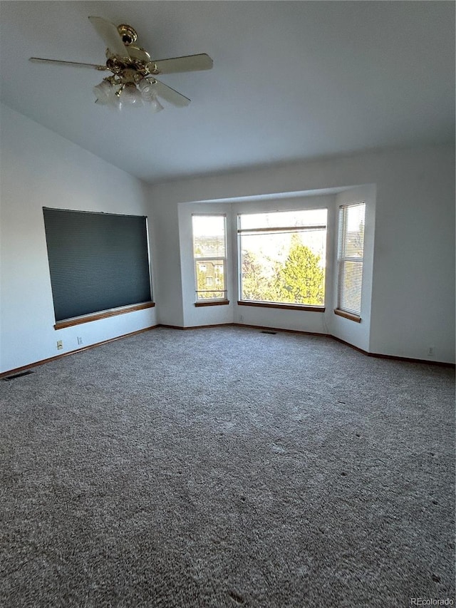 carpeted spare room featuring ceiling fan and lofted ceiling