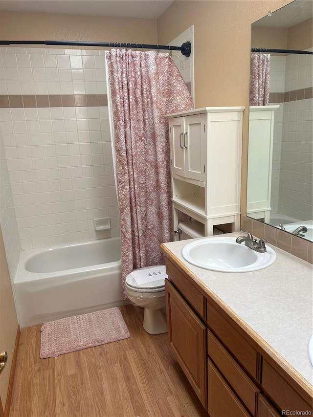 full bathroom featuring toilet, hardwood / wood-style floors, vanity, and shower / tub combo with curtain