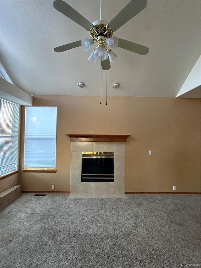 unfurnished living room with carpet flooring, ceiling fan, a fireplace, and vaulted ceiling