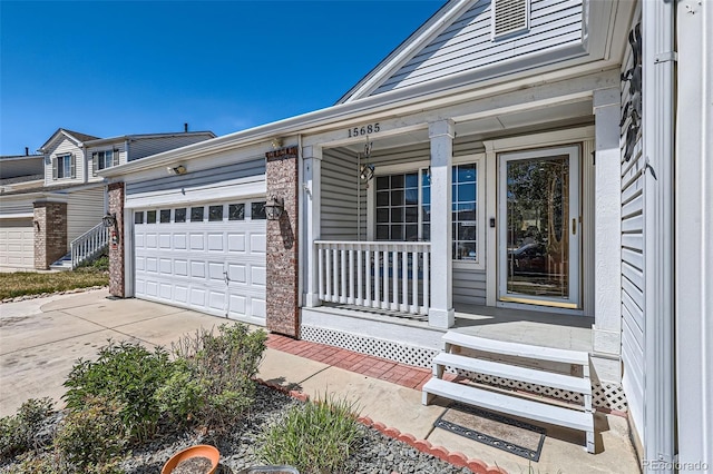 15685 E 50th Ave, Denver, CO 80239 - property entrance featuring driveway, covered porch, and an attached garage