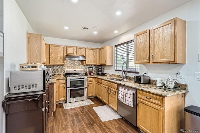 15685 E 50th Ave, Denver, CO 80239 - kitchen featuring light stone countertops, under cabinet range hood, dark wood finished floors, a sink, and appliances with stainless steel finishes