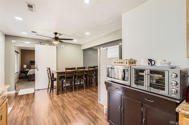 15685 E 50th Ave, Denver, CO 80239 - dining area featuring light wood-style flooring, recessed lighting, a barn door, ceiling fan, and visible vents