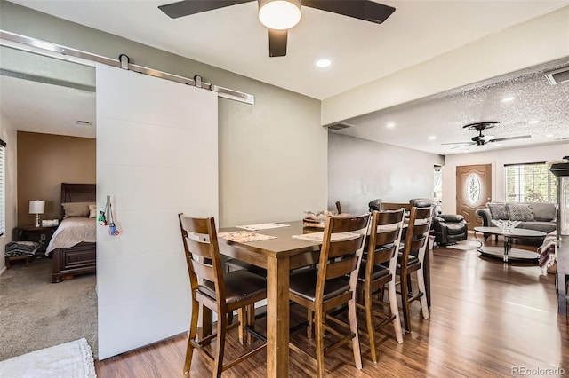 15685 E 50th Ave, Denver, CO 80239 - dining area featuring a ceiling fan, recessed lighting, a barn door, visible vents, and wood finished floors