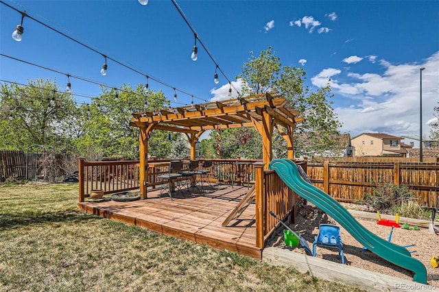 15685 E 50th Ave, Denver, CO 80239 - deck with a lawn, outdoor dining space, a playground, a pergola, and a fenced backyard