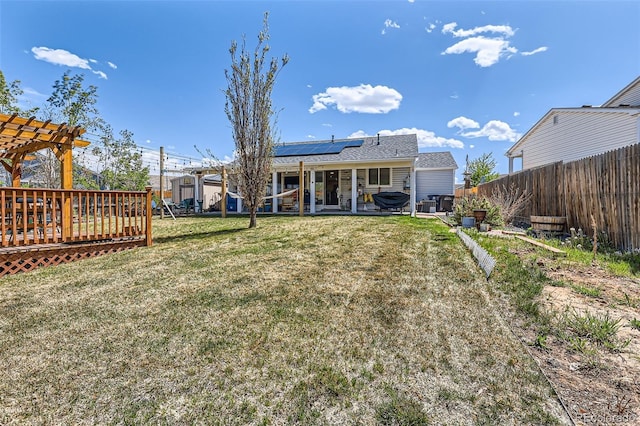 15685 E 50th Ave, Denver, CO 80239 - back of property with a patio area, a yard, a pergola, roof mounted solar panels, and a fenced backyard