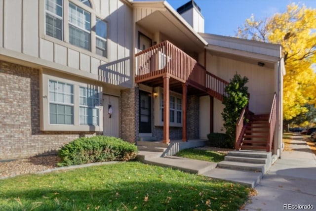 exterior space featuring brick siding, board and batten siding, and a balcony