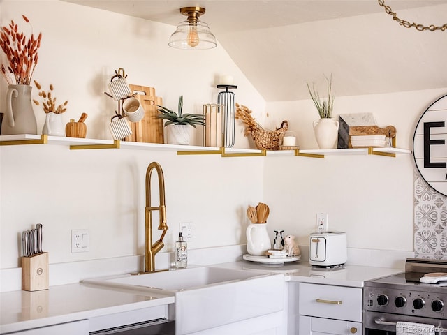 interior space featuring lofted ceiling, light countertops, a sink, and stainless steel electric stove